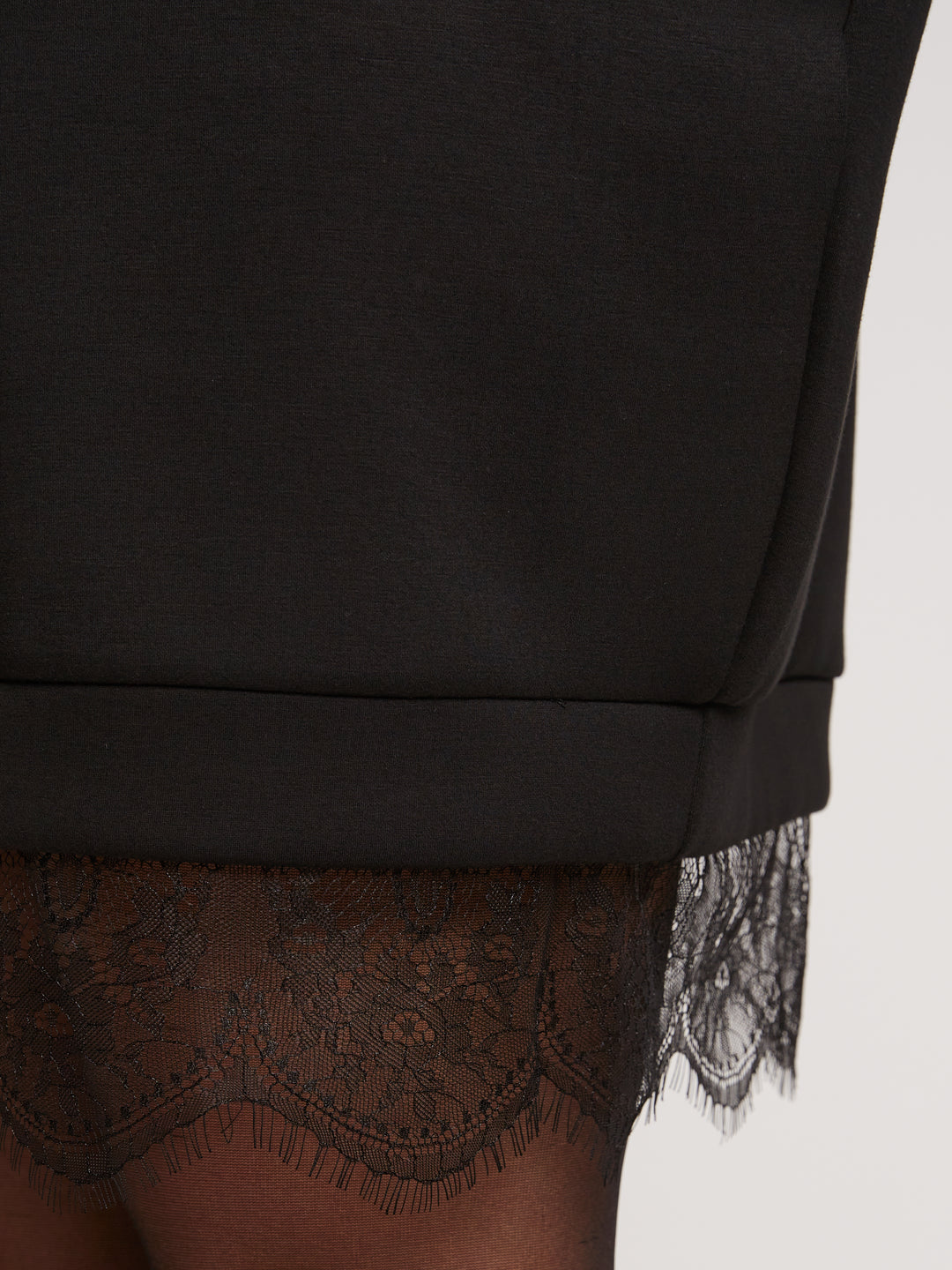 schwarzes Pulloverkleid mit Spitzensaum 